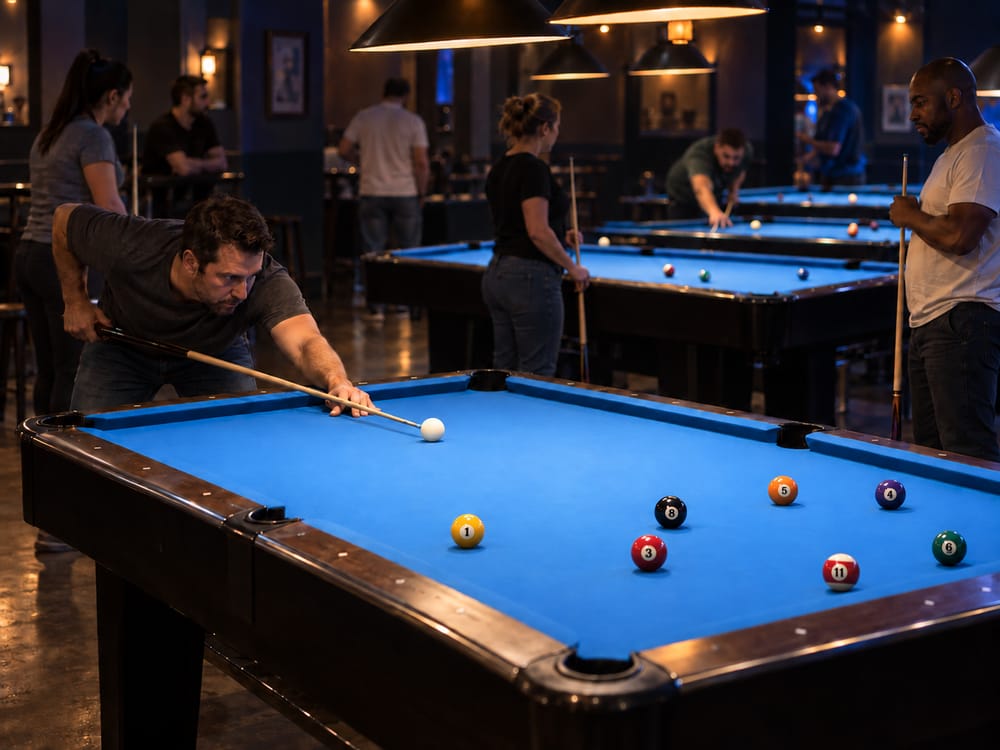 Adults play and wait beside illuminated tables at a pool tournament.